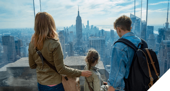 Viajes en familia. Experiencias para todos. Una familia mira el Empire State en Nueva York desde la azotea.