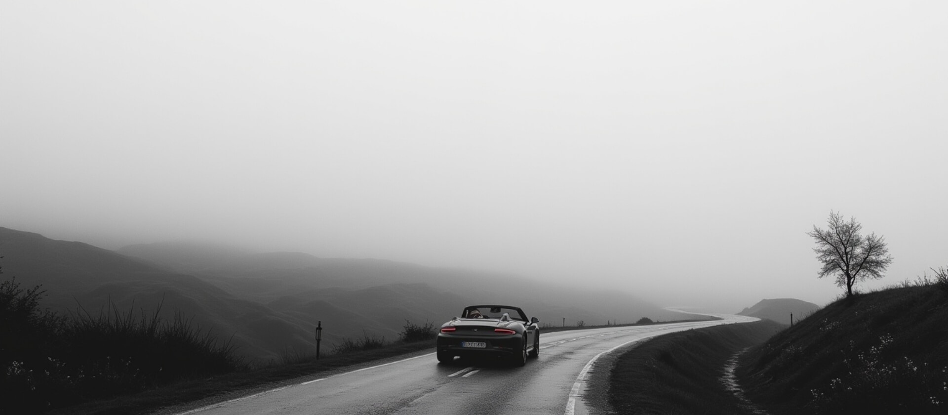 Experiencias premium. Donde tu quieras ir Nosotros vamos contigo. Un coche descapotable se aleja por una carretera envuelta en niebla