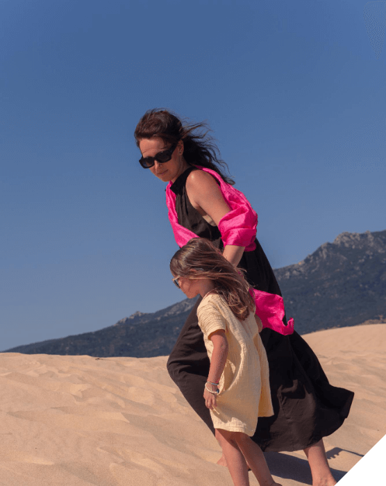 Viajes en familia. Viajes originales. Una madre y su hija pasean por las dunas de arena en Dubai
