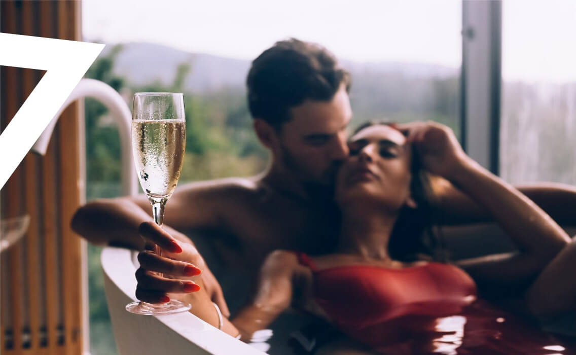 Viajes de novios. Una pareja en una bañera con una copa de champán