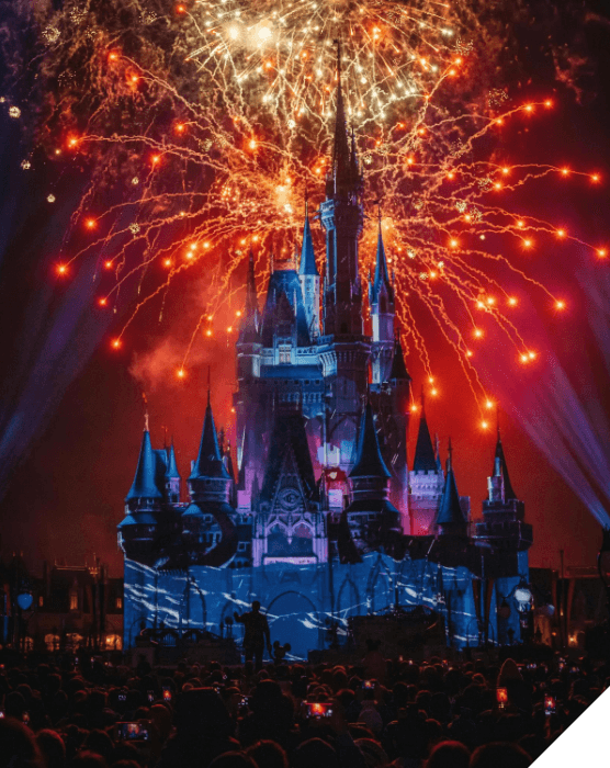 Viajes en familia. Experiencias diferentes. Un castillo en el parque de Disney por la noche con fuegos artificiales