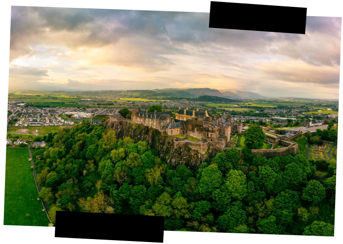 Viajes a medida. Viajes que inspiran. Panorámica del castillo medieval en Stirling rodeado de un bosque verde