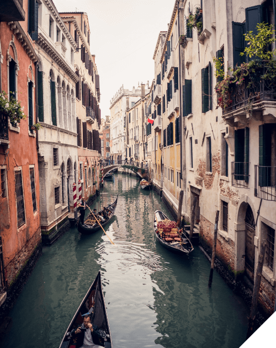 Viajes de novios. Verano. Una calle inundada de Venecia con tres góndolas y un puente a lo lejos