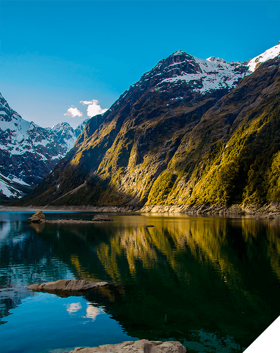 Viajes de novios. Invierno. Un lago al pie de unas montañas con las cumbres nevadas