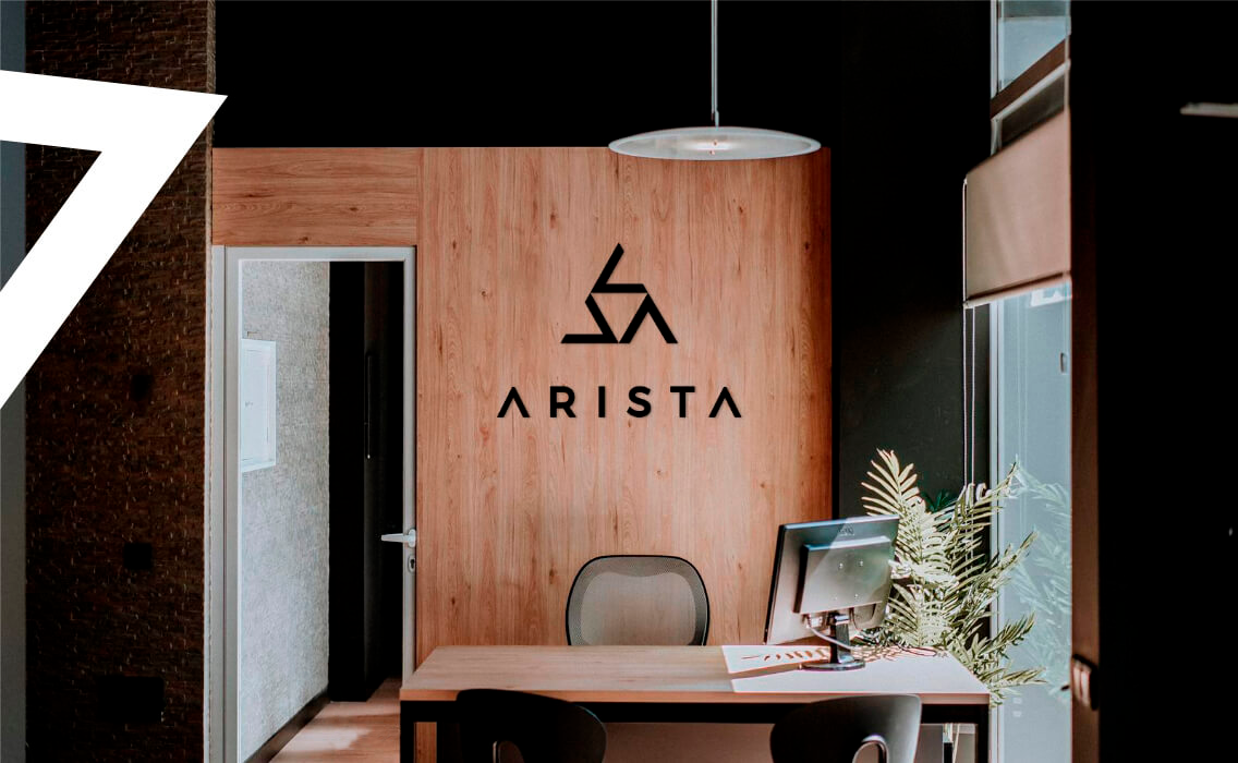 Viajes Arista. Oficina con pared de madera y escritorio con silla y pantalla de ordenador