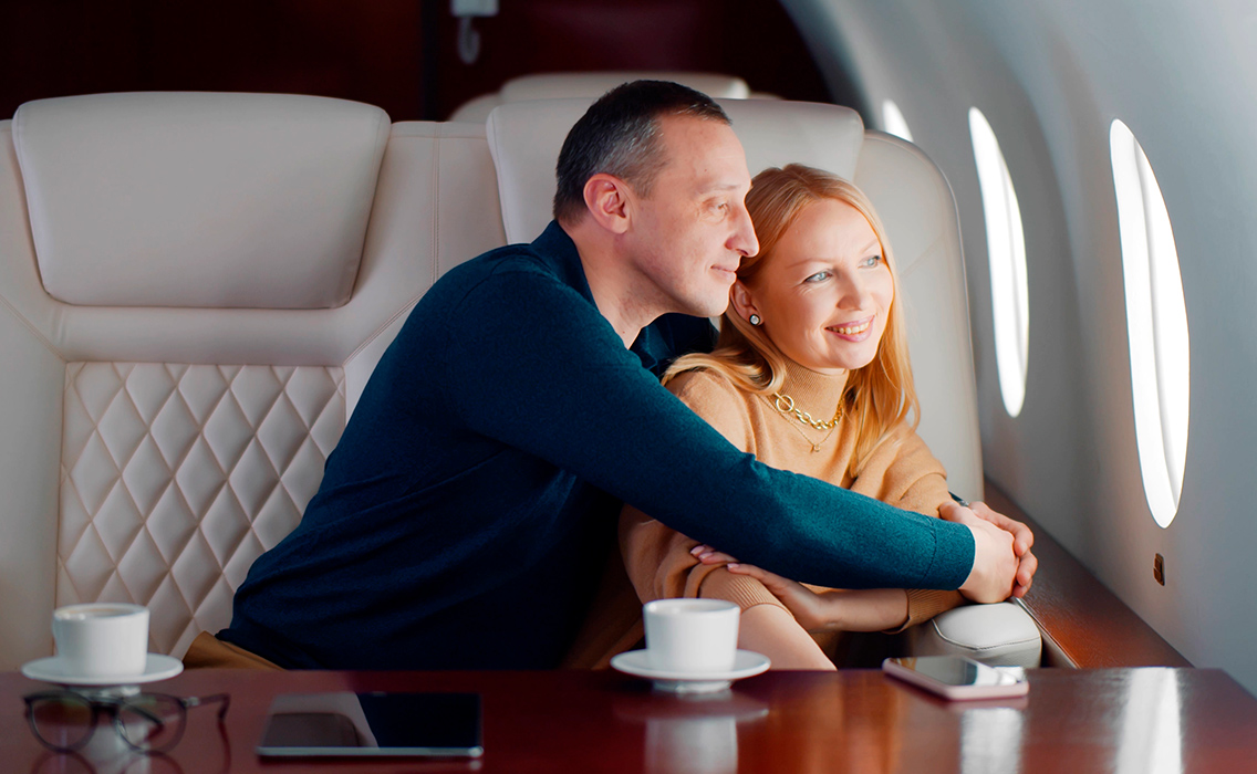Pareja disfrutando de su vuelo en primera clase durante un viaje de lujo a medida sin jet lag