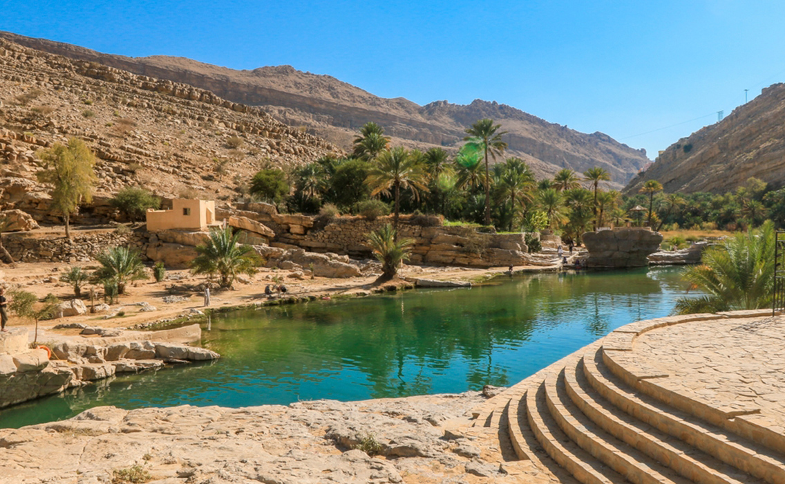 Oasis de aguas turquesas en Wadi Shab, un destino exclusivo para viajes de lujo en Omán.
