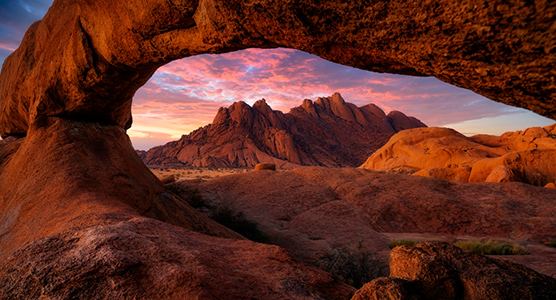 Arco de roca en Spitzkoppe al atardecer en Namibia, paisaje icónico del desierto durante un viaje de lujo a Namibia a medida.