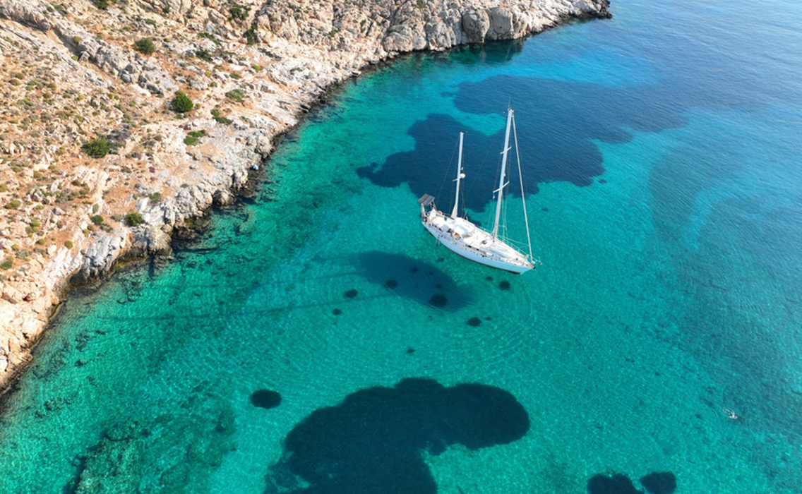Velero de lujo navegando por la costa de Menorca, frente a las aguas cristalinas del entorno del Camí de Cavalls.