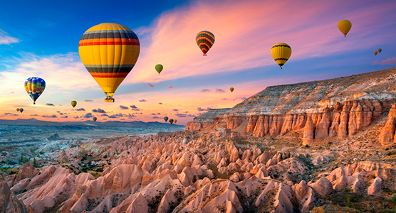 Globos aerostáticos sobrevuelan los valles de Capadocia al amanecer durante un exclusivo viaje de lujo a medida por Turquía.