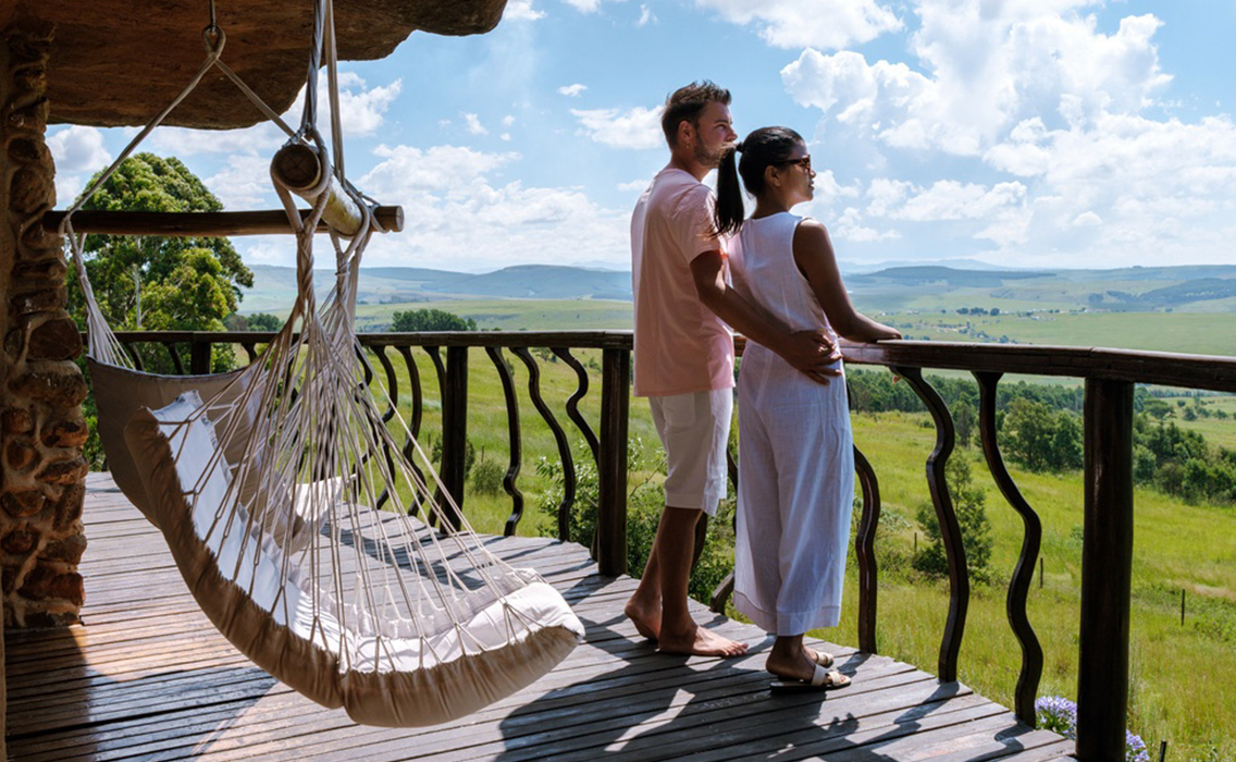Pareja relajándose en una cabaña de lujo con vistas a la sabana, disfrutando de una experiencia de viaje a medida donde la naturaleza marca el ritmo.