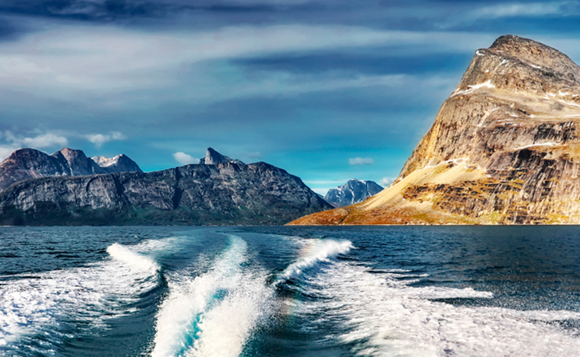 Estela de un barco navegando entre glaciares de Groenlandia, una travesía exclusiva por los paisajes más remotos del Ártico.