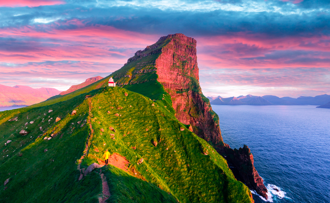 Faro de Kallur entre las verdes colinas de la isla de Kalsoy al atardecer, en un viaje a medida por las Islas Feroe.